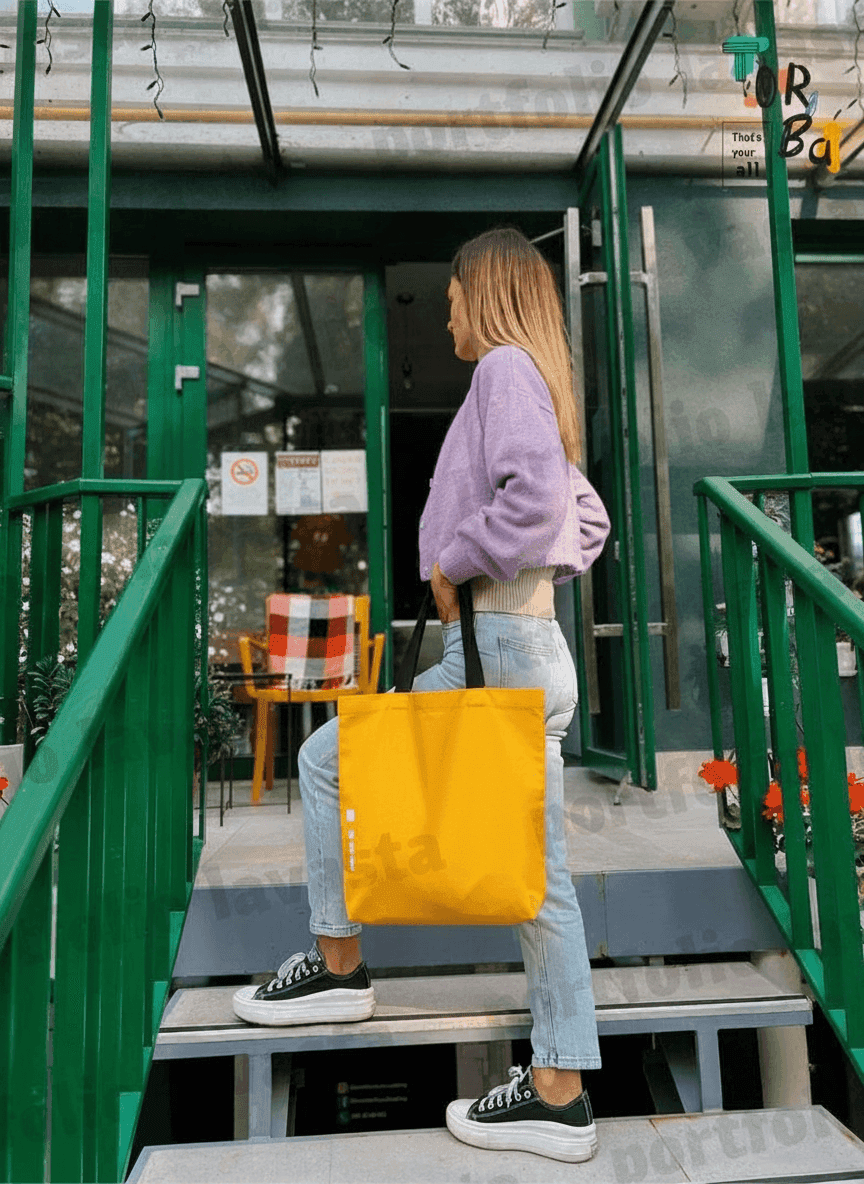 Yellow tote bag with black handles & exterior pocket