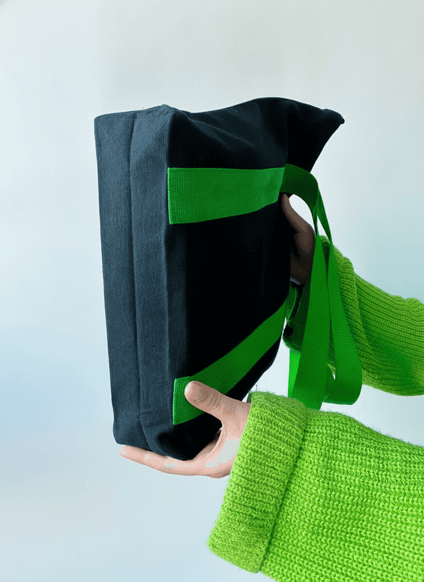 Black tote bag with long green handles